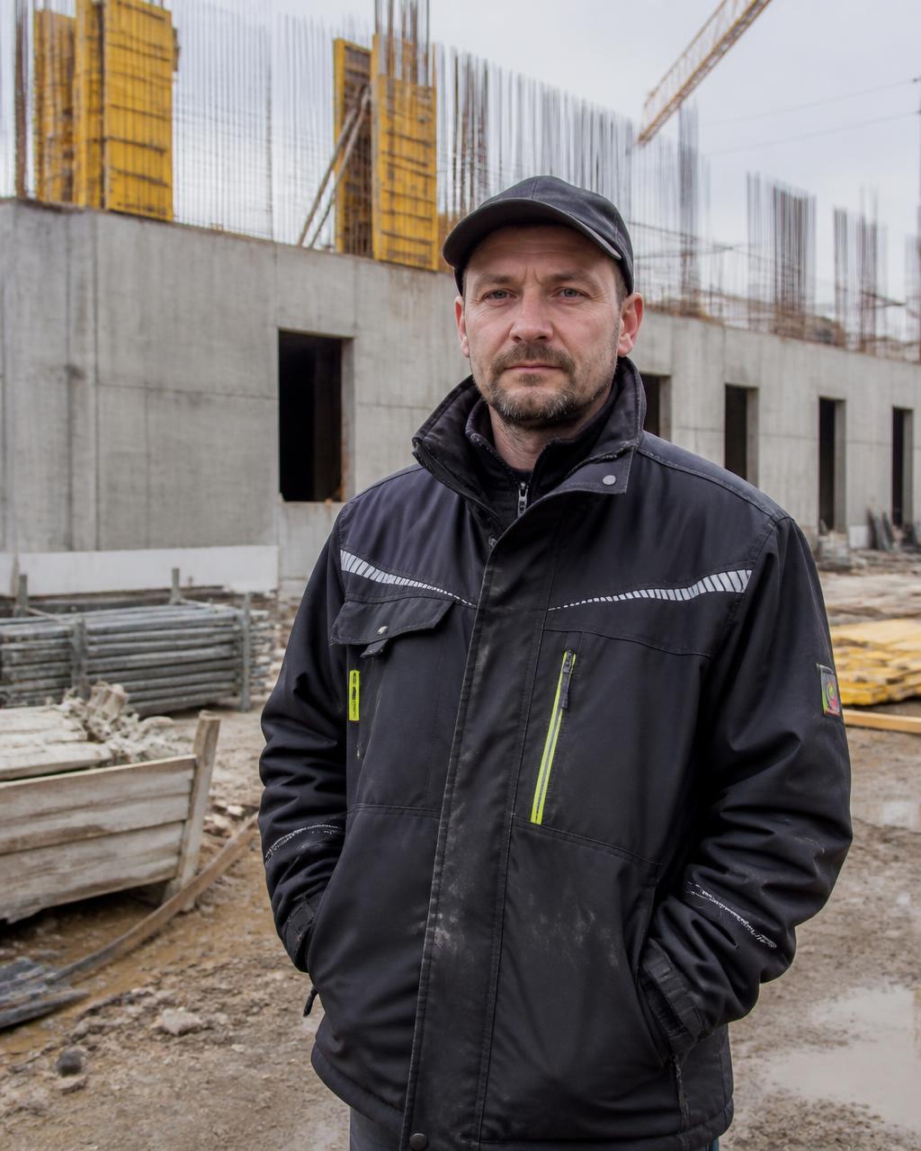 Stavbyvedoucí v pracovním oděvu na rozestavěné stavbě